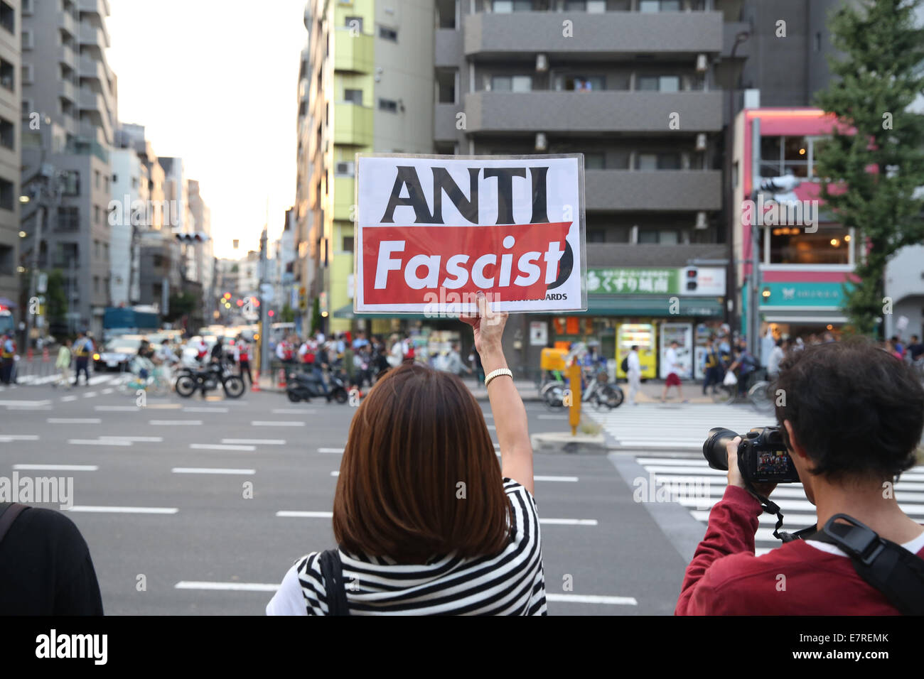 Tokio, Japón. El 23 de Sept, 2014. Un anti-racista, sostiene un cartel durante una manifestación contra los racistas" de marzo en Tokio, 23 de septiembre de 2014. Cientos de miembros de Zaitokukai, un grupo de ultra-derecha contra privilegios extendidos a los extranjeros a quienes se ha concedido el estatuto de residente extranjero especial, se movilizaron y marcharon en Roppongi, una zona del centro de Tokio, y chocaron con anti-racistas aquí el lunes, destacando el nacionalismo del Japón-problema inclinada. Crédito: Liu Tian/Xinhua/Alamy Live News Foto de stock