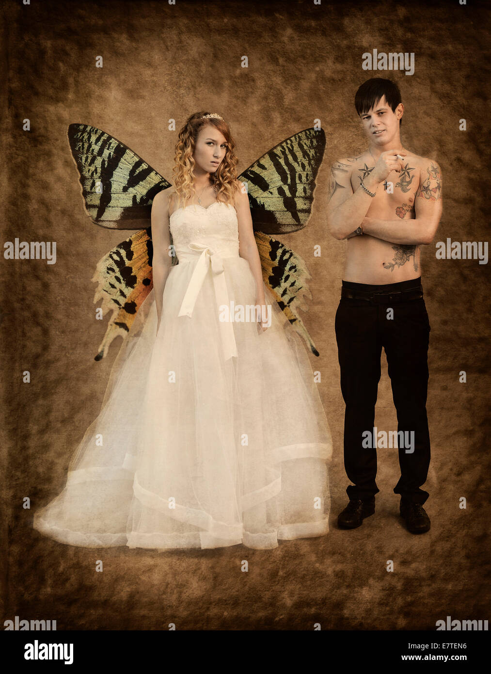 Fotografía de bodas, la novia y el novio, novia con alas de mariposa y un  desnudo chested novio con tatuajes, sosteniendo un cigarrillo Fotografía de  stock - Alamy