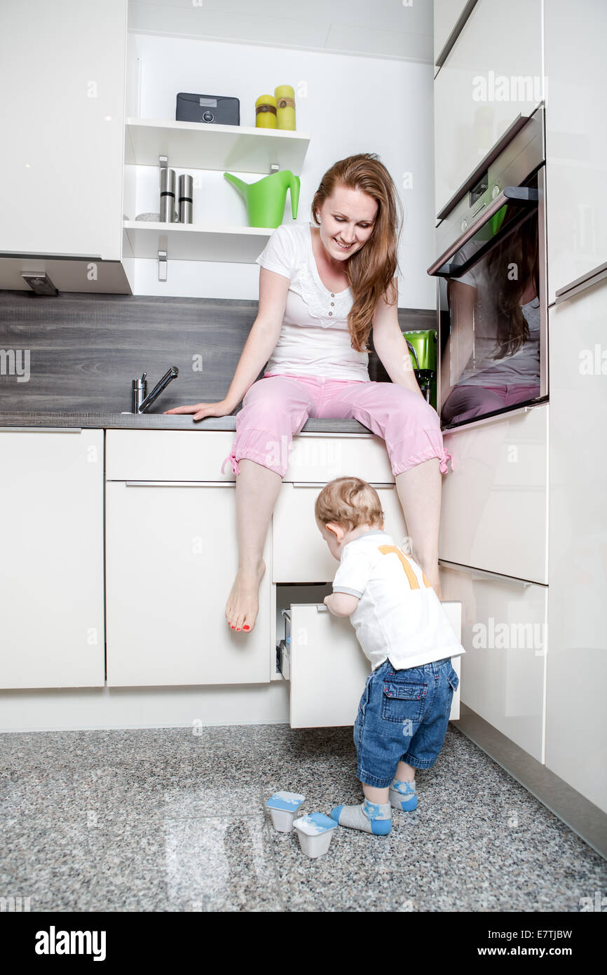 Mujer con un niño de 1,5 años en la cocina Foto de stock