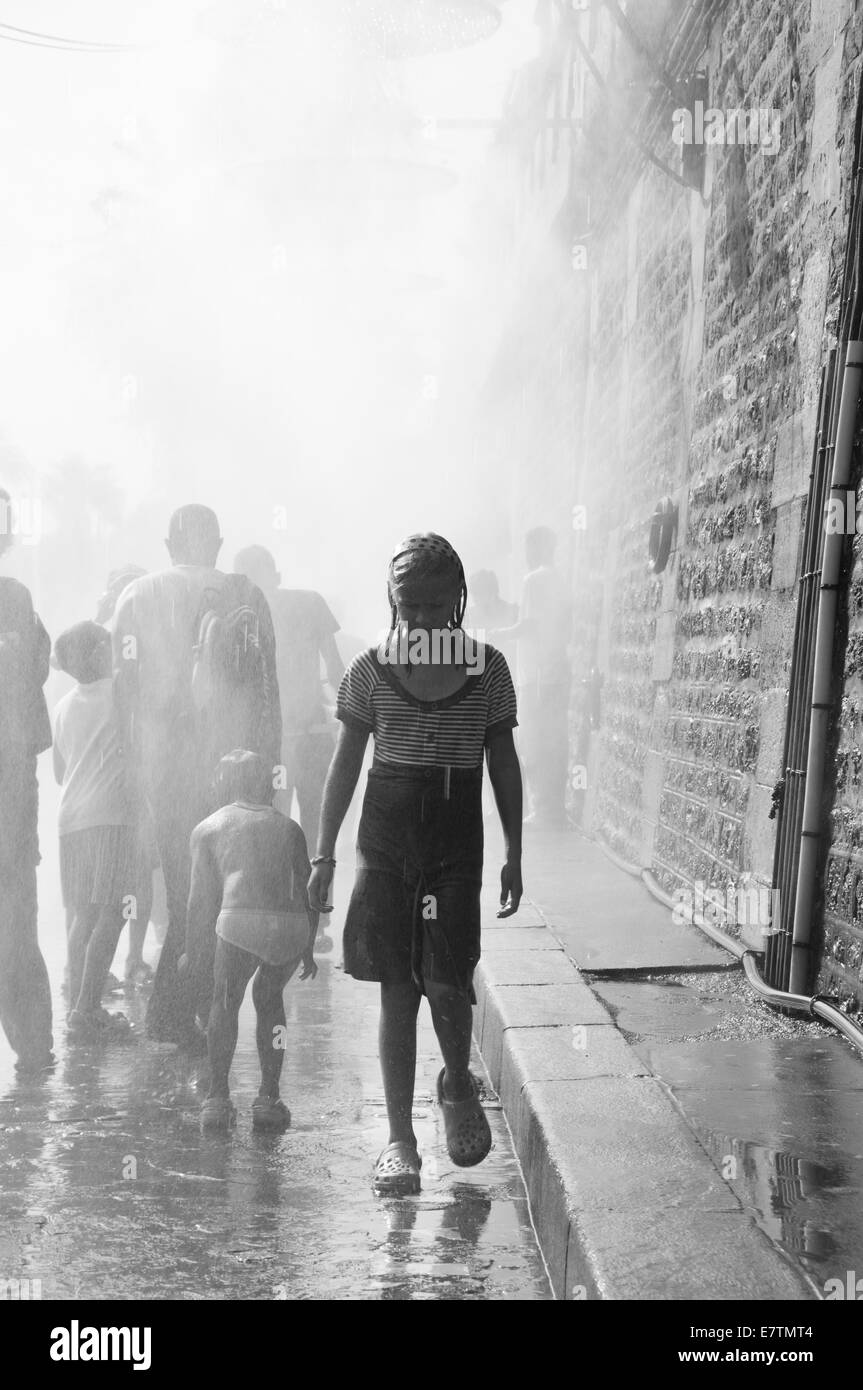 Joven emergente de una multitud en la lluvia Foto de stock