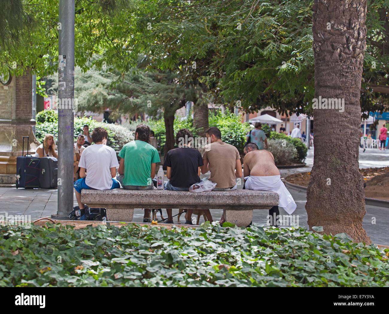 Los muchachos de Neet sentado en un banco en un parque de la ciudad de Palma de Mallorca, España Foto de stock