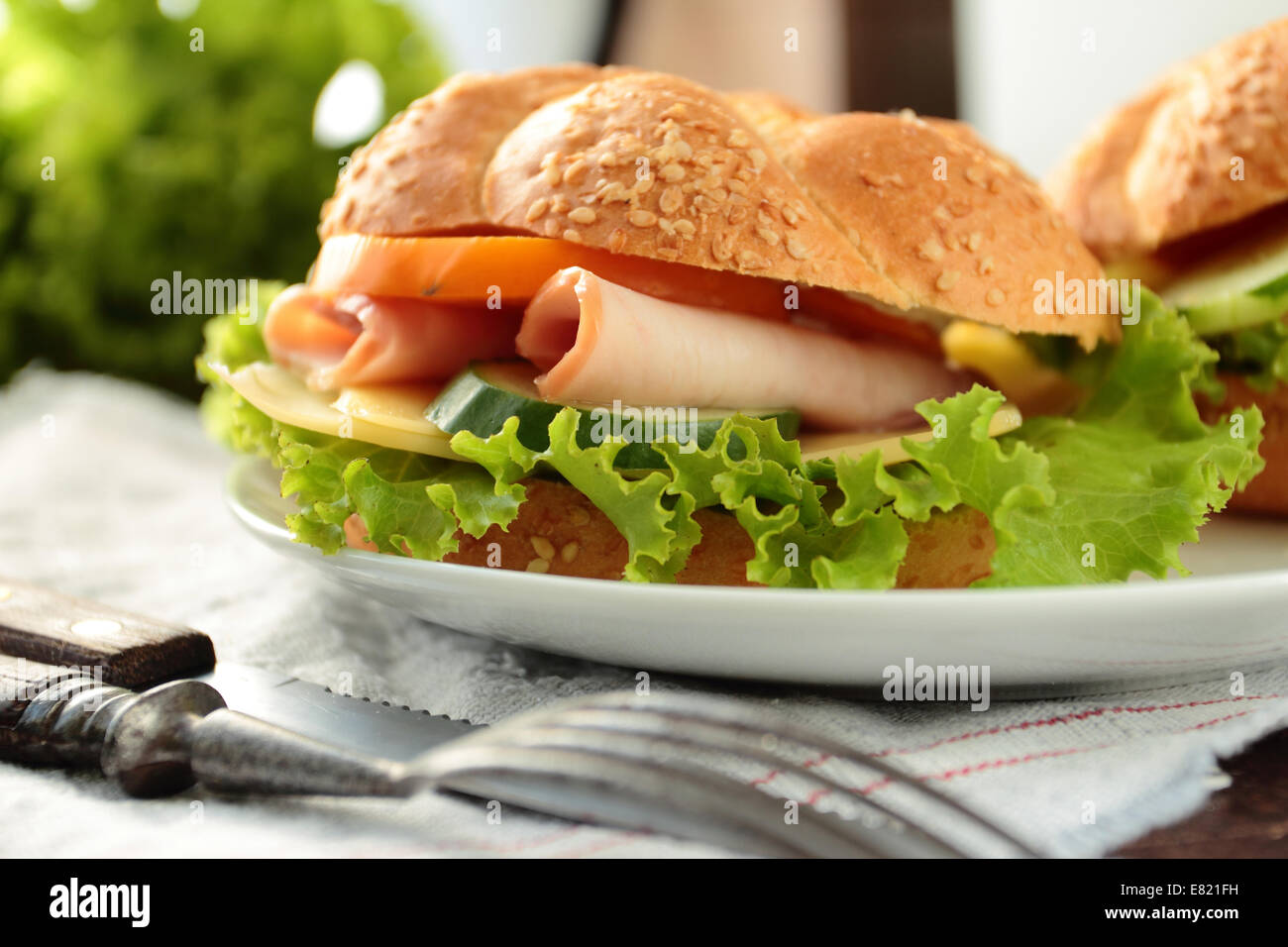 Sándwich con lechuga fresca, tomate, jamón y queso Foto de stock