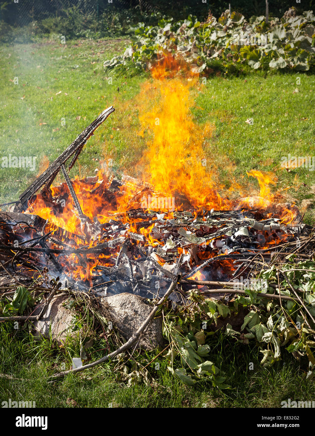 Basura en fuego, jardín ilegal quemar basura. Foto de stock