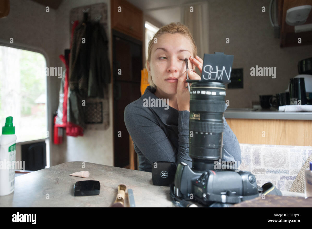 Modelo se aplica el maquillaje en RV utilizando la cámara como espejo stand Foto de stock