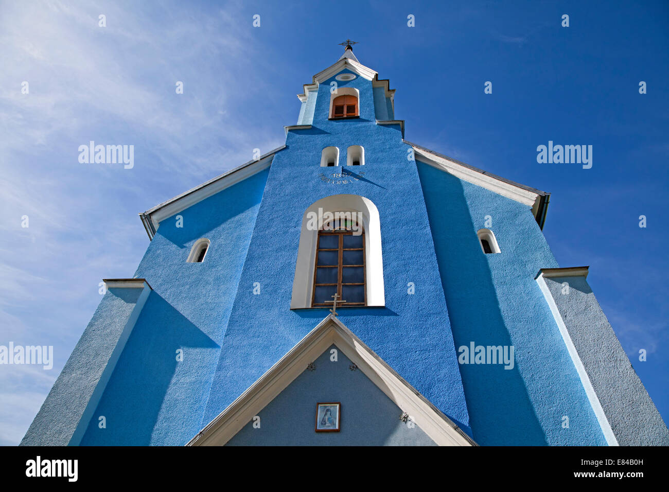 Iglesia Católica contra el cielo azul, vista desde abajo Foto de stock