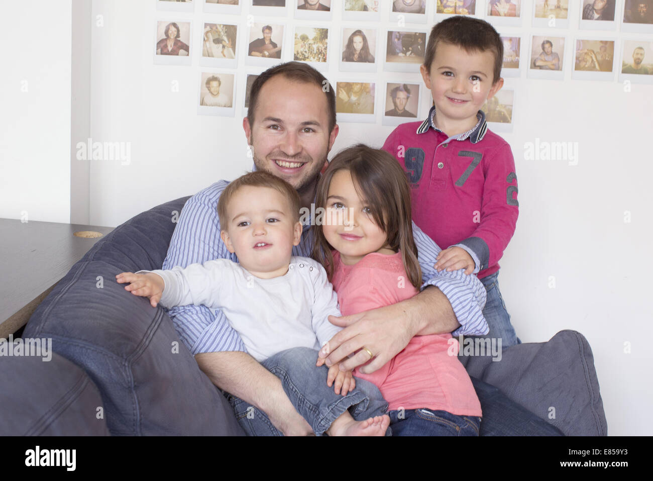El padre y los hijos sentados juntos en el sofá, Retrato Foto de stock