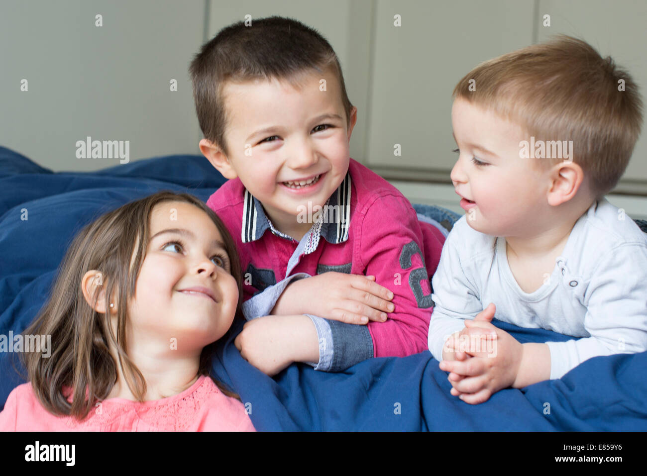 Hermanos jóvenes relajándose juntos en la cama Foto de stock