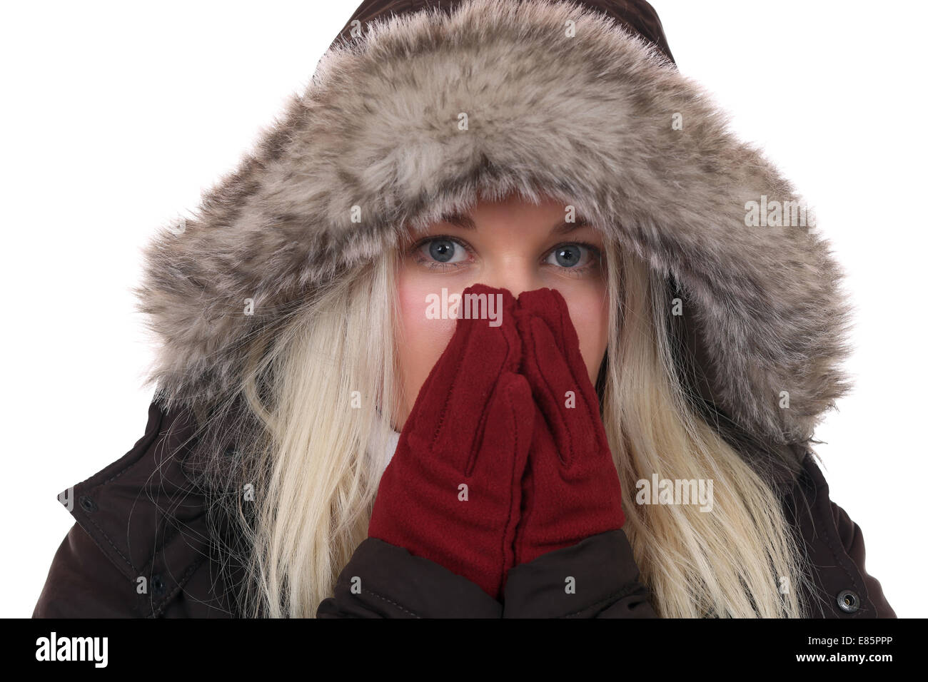 Mujer joven de congelación en el frío en invierno con guantes y gorro, aislado en un fondo blanco. Foto de stock