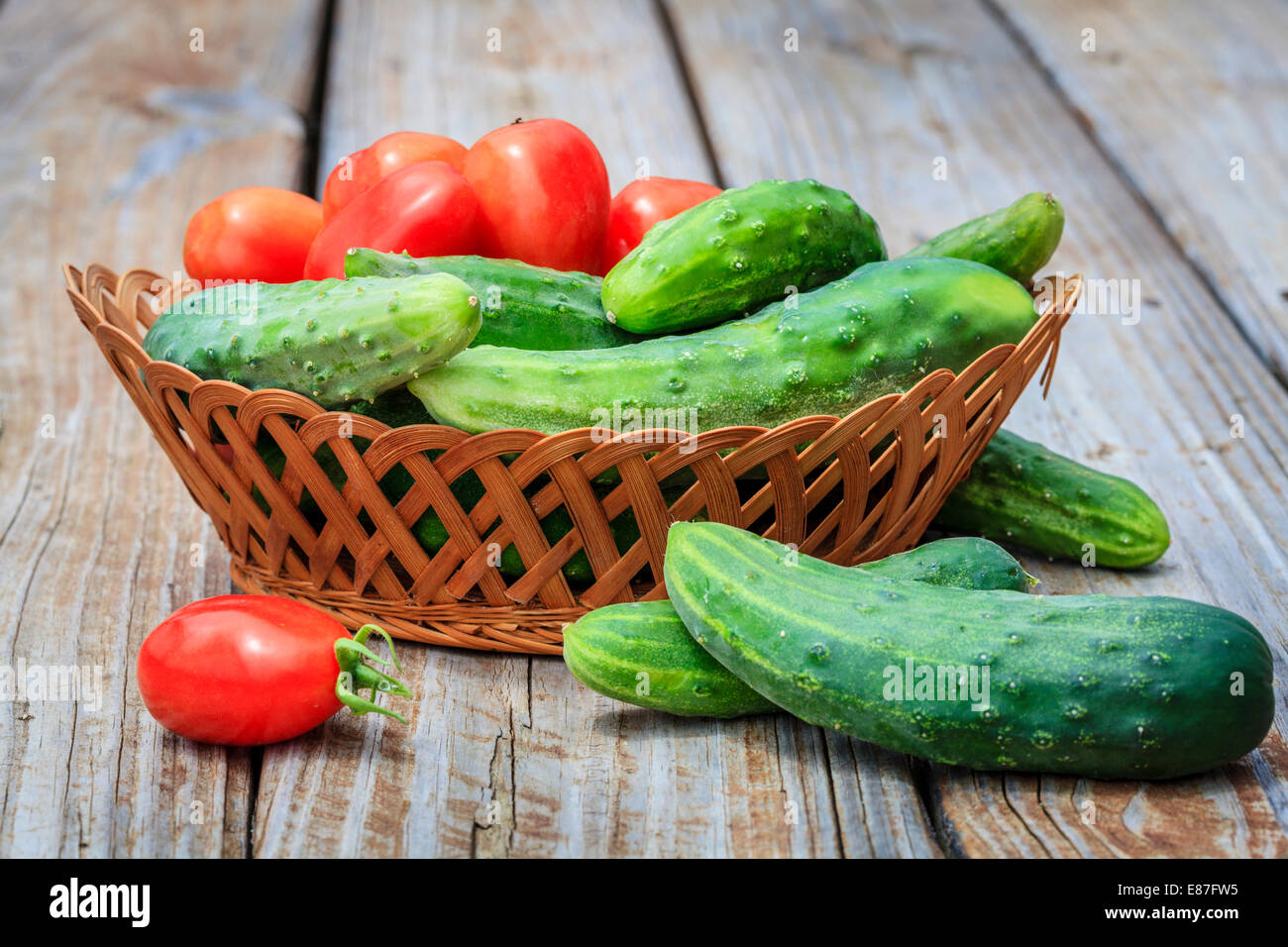 Cesta con tomates y pepinos frescos del jardín Foto de stock