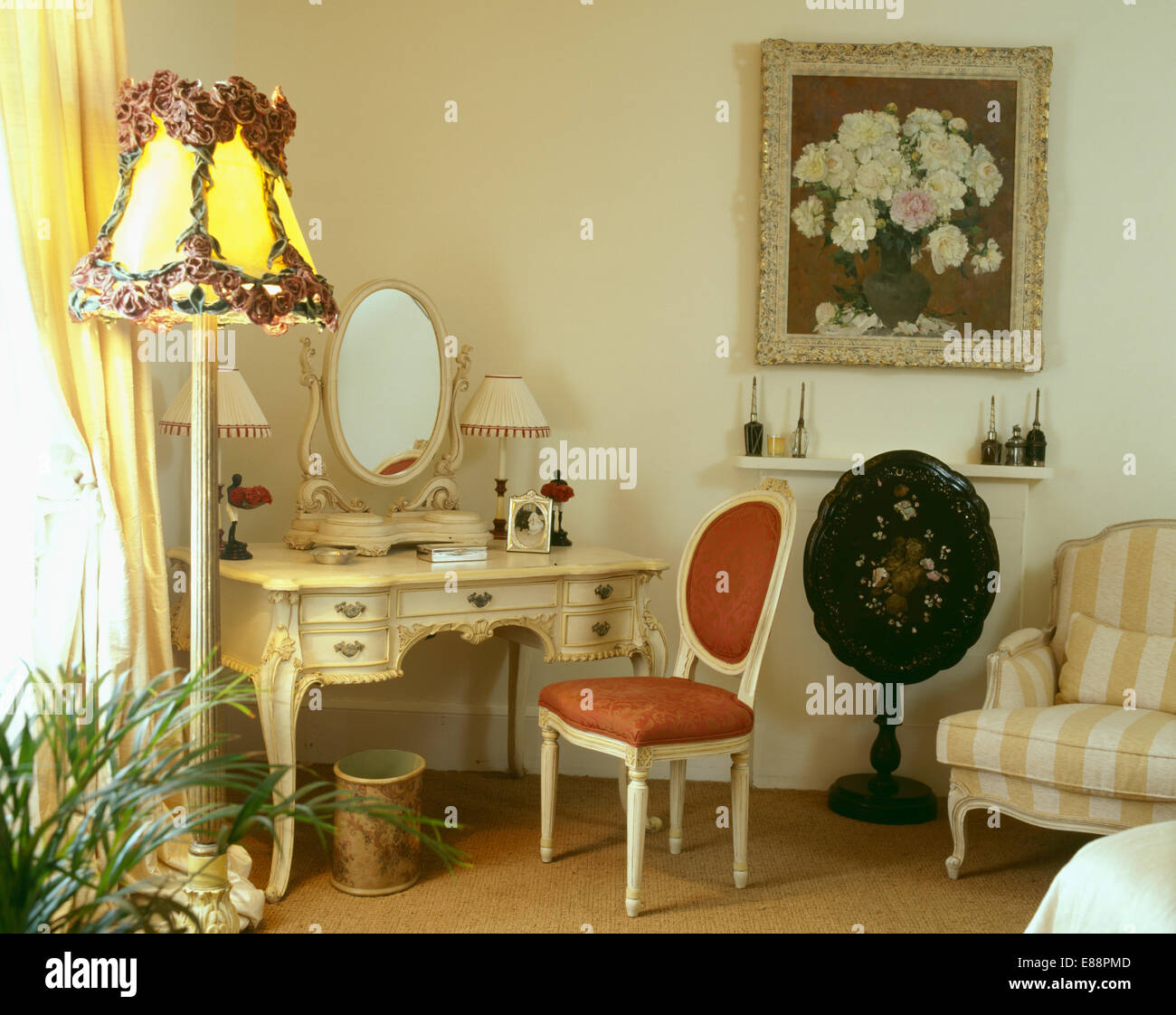 Silla de estilo francés en crema de tocador pintada en la habitación  iluminada con luz estándar y antiguos tabla inclinada Fotografía de stock -  Alamy