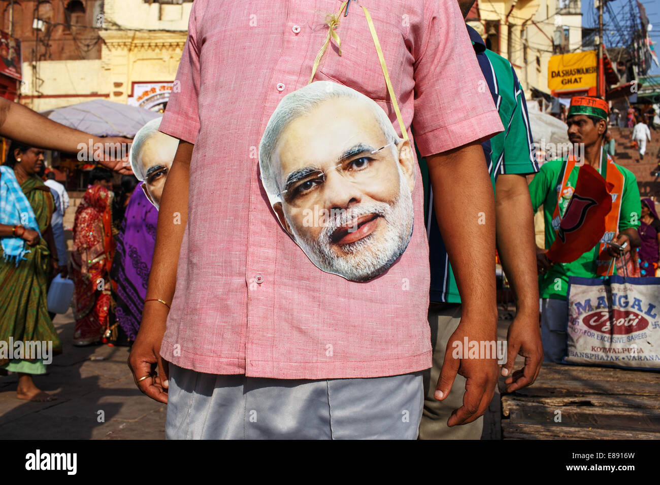 Las personas con máscaras mostrando el rostro del primer ministed Narendra Modi en Varanasi, India. Befre elecciones en 2014. Foto de stock