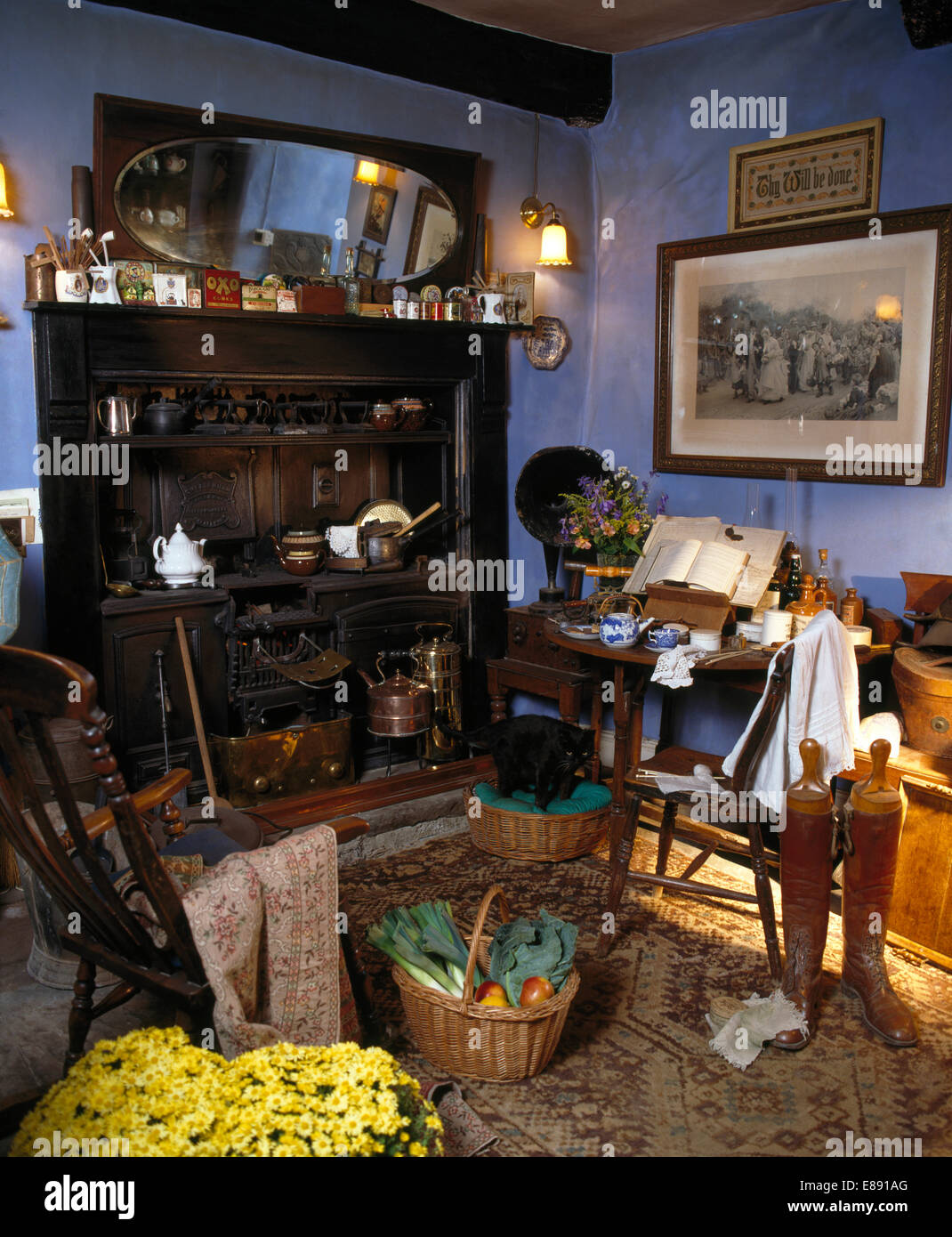 Gama victoriano en la antigua cocina azul con cesta de verduras y viejas botas de montar Foto de stock