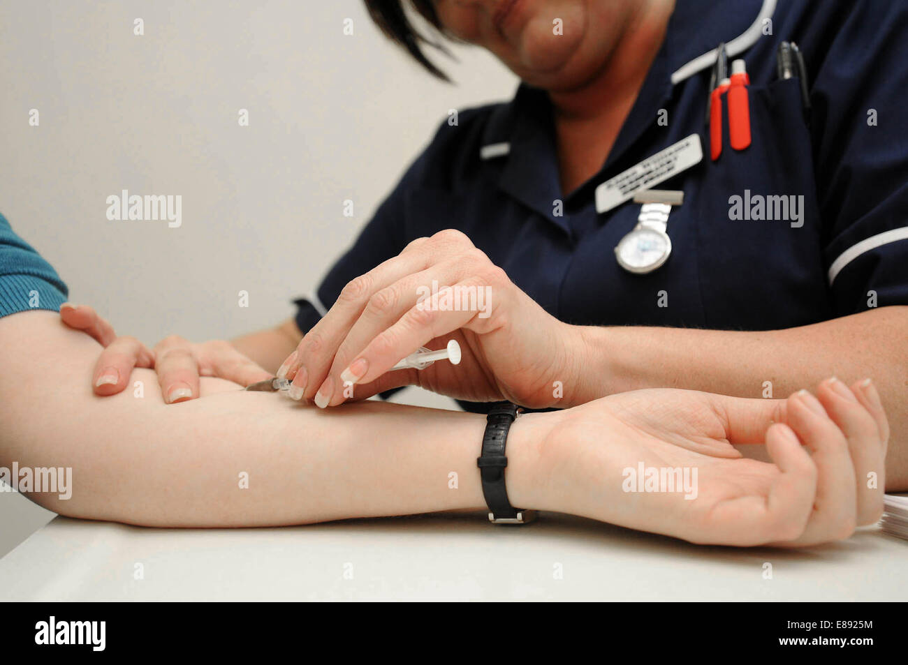 Una enfermera administra la vacuna a través de inyección para un paciente en un centro médico en Rhondda, Gales del Sur. Foto de stock