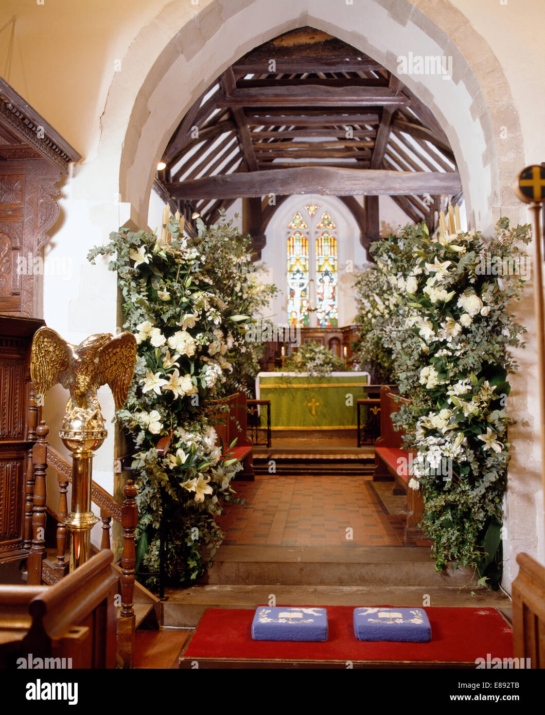 País iglesia decorada para una boda con lirios blancos en suntuosos arreglos florales Foto de stock