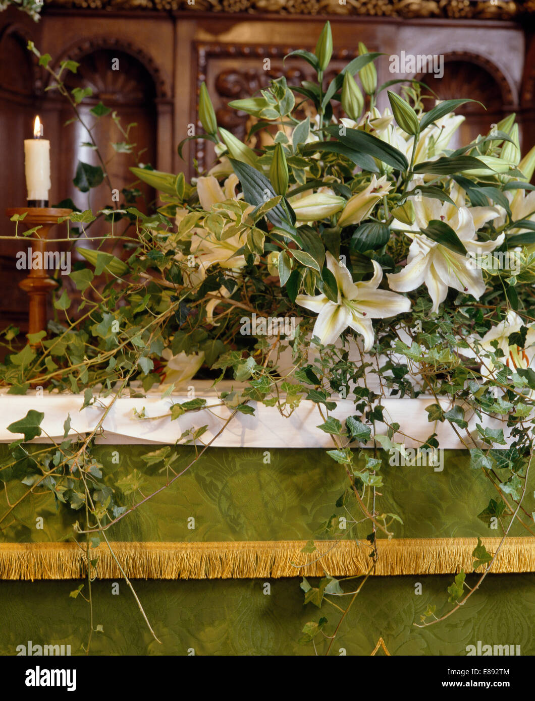 Close-up de arreglo floral de lirios blancos y hiedra en el altar de la  iglesia del país decorado para una boda de verano Fotografía de stock -  Alamy