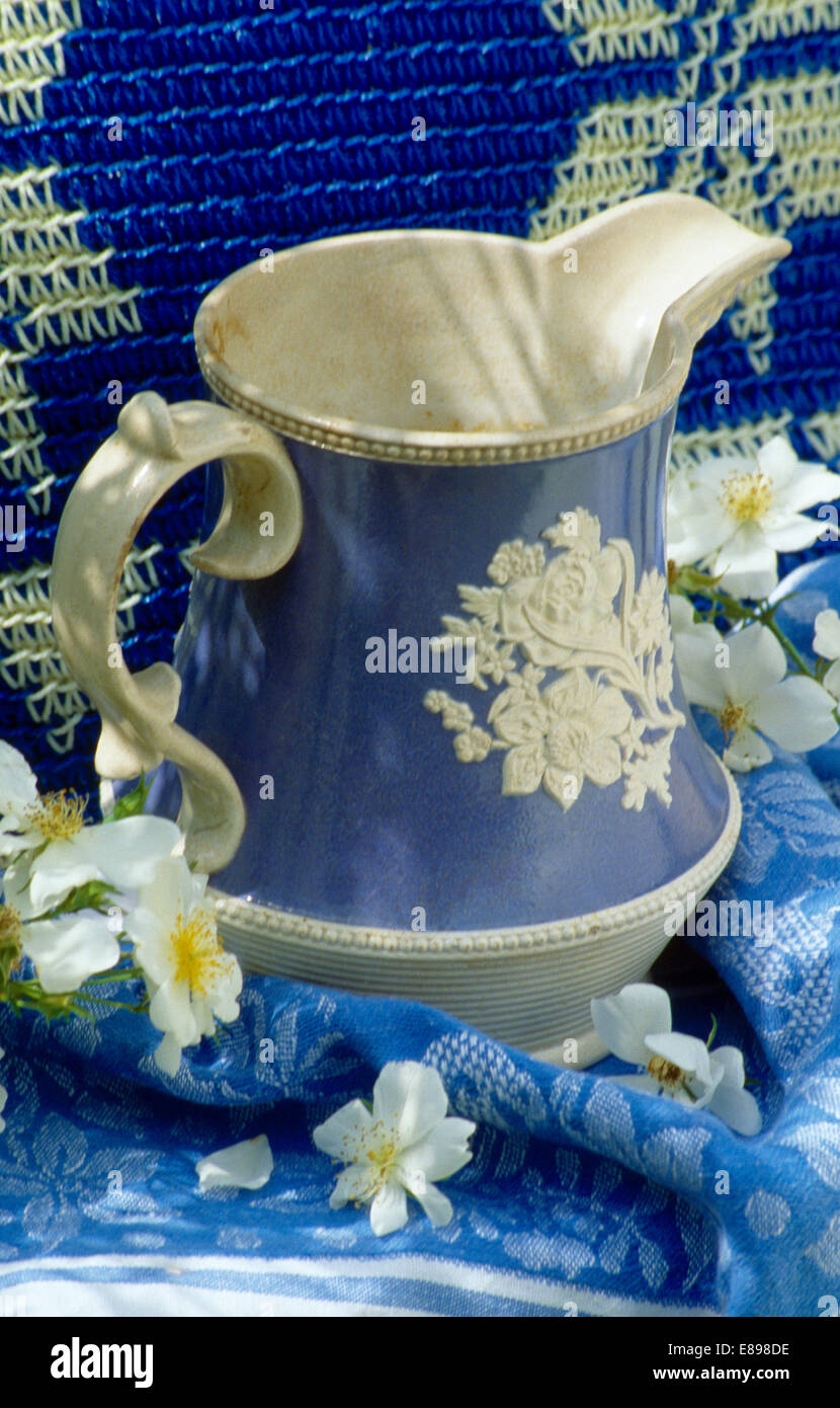 De Still-Life antique blue+jarra sobre azul colcha blanca Foto de stock
