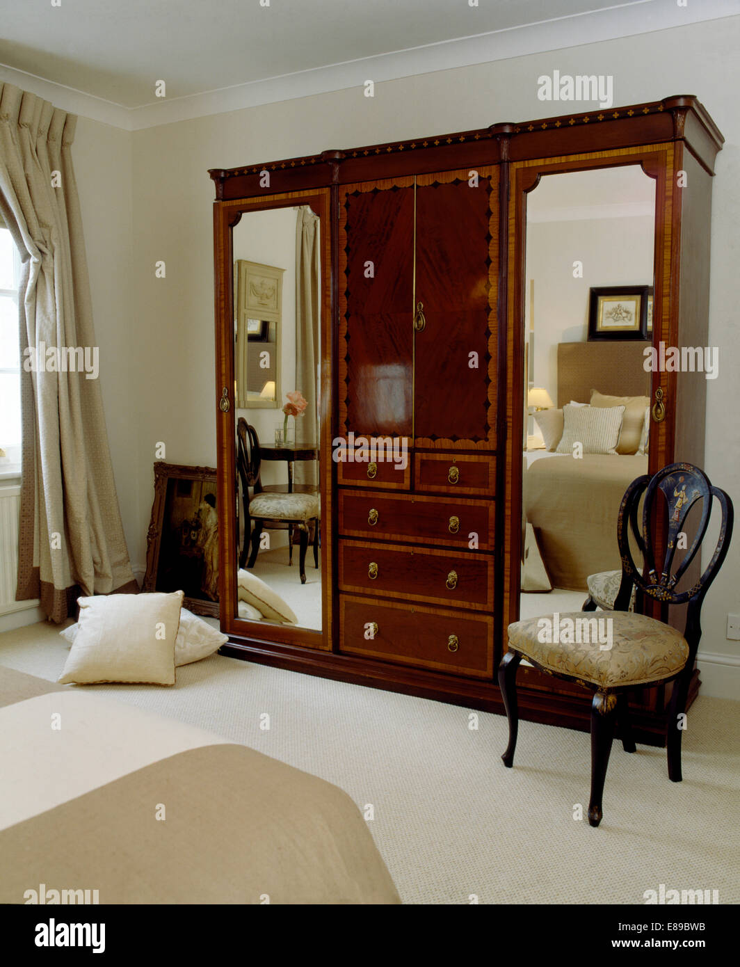 Silla antigua junto a grandes armarios con espejos en las puertas de casa  habitación con alfombra blanca Fotografía de stock - Alamy