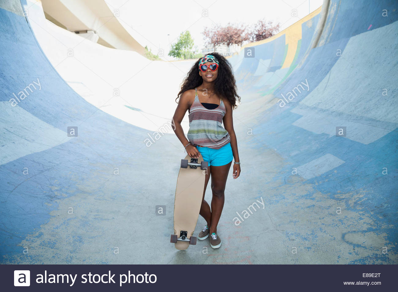 Retrato de una adolescente la celebración de skateboard en la rampa Foto de stock
