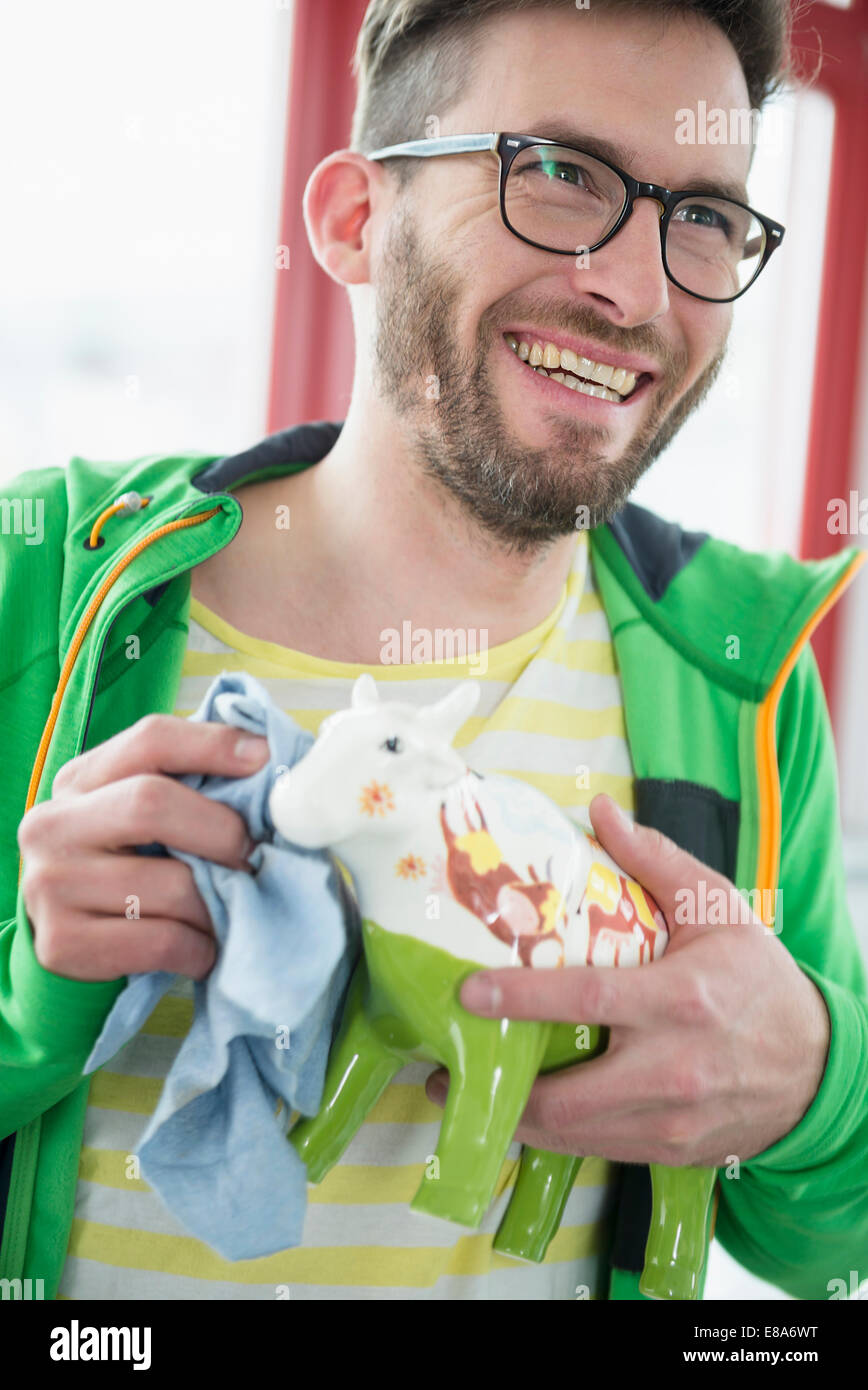 Joven sonriente paño de limpieza ornamento de vaca Foto de stock