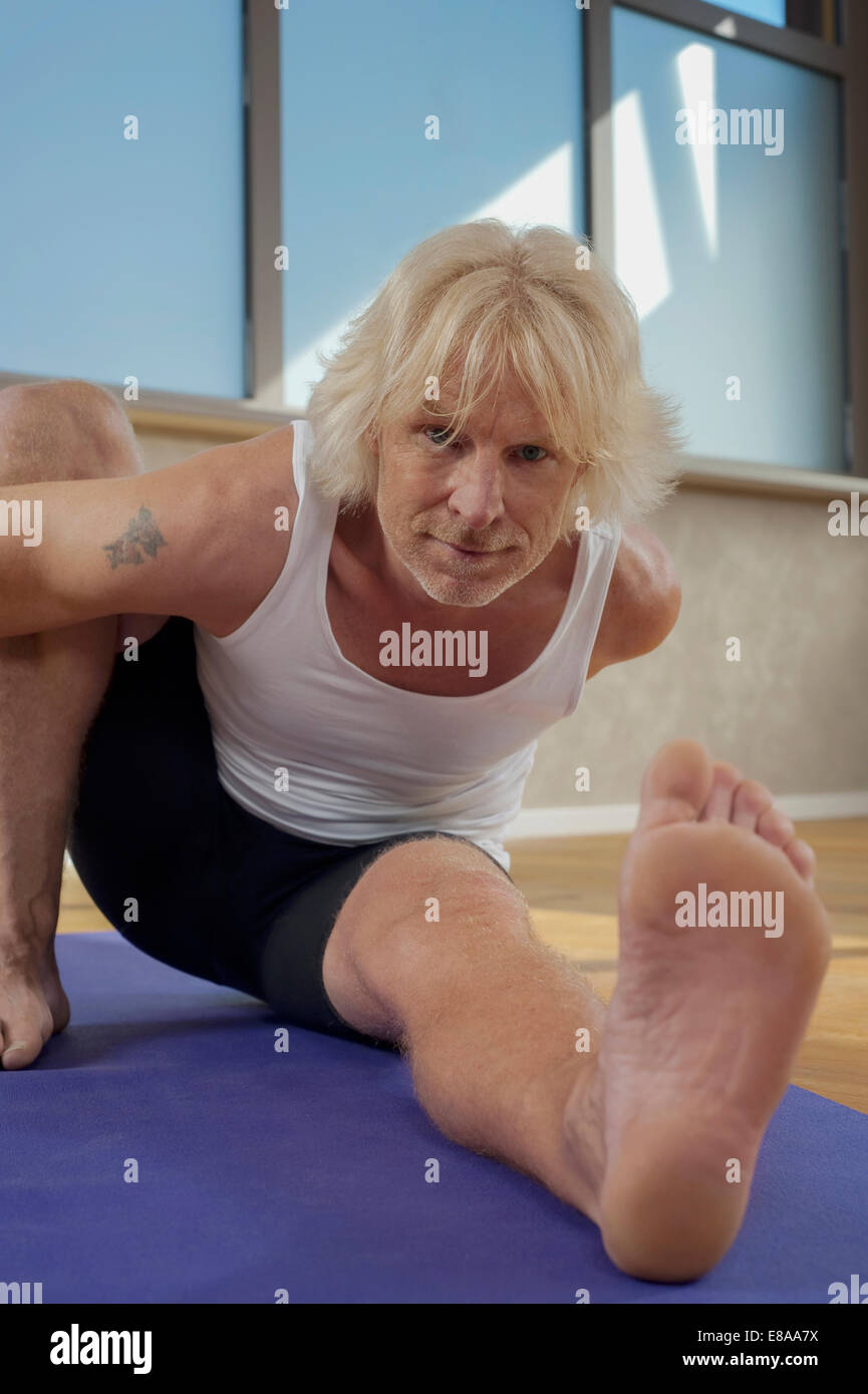 Hombre maduro, estudio de Yoga ejercicios de estiramiento Foto de stock