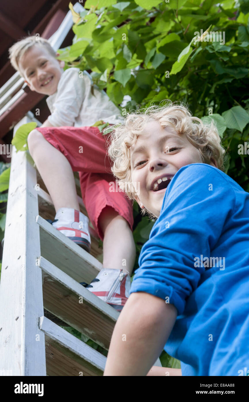 Los muchachos amigos escalera casa-árbol Foto de stock