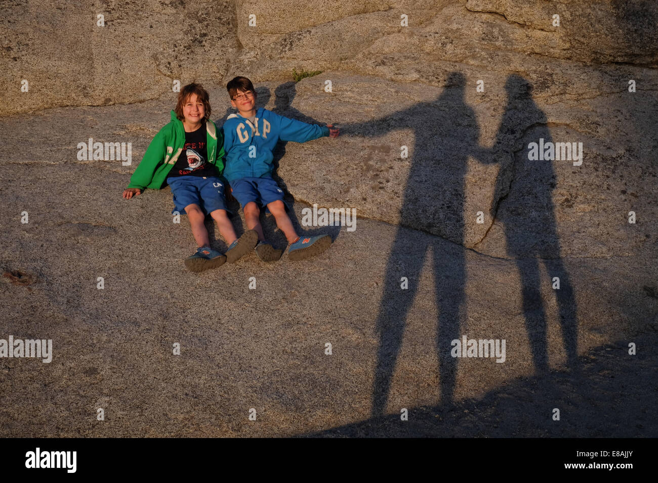 Dos jóvenes mantenga la sombra de su mamá y papá manos Foto de stock