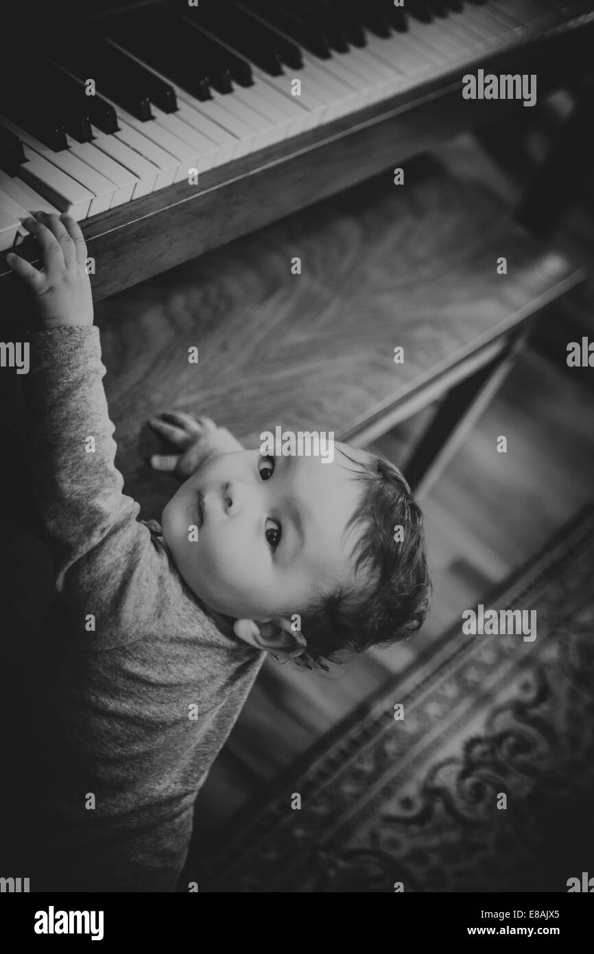 Blanco y negro sincero retrato de una niña tocando el piano Foto de stock