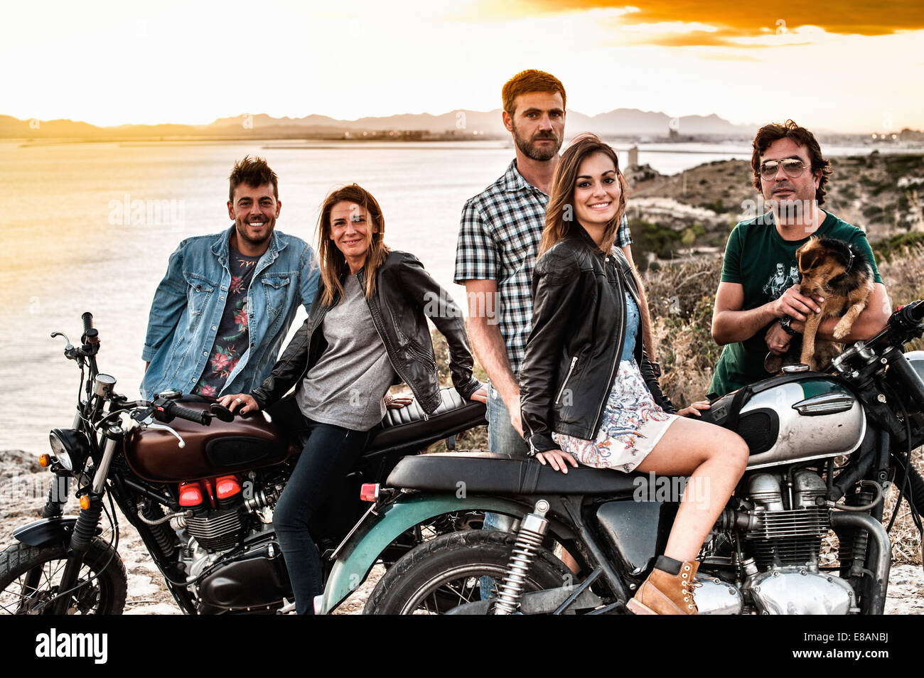 Retrato de cinco amigos de motociclismo en la costa al atardecer, Cagliari, Cerdeña, Italia Foto de stock