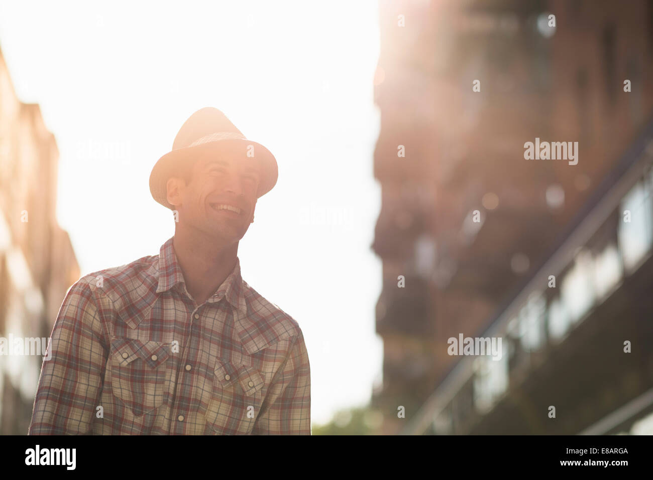 Joven hombre vestido con sombrero y camisa marcada Foto de stock