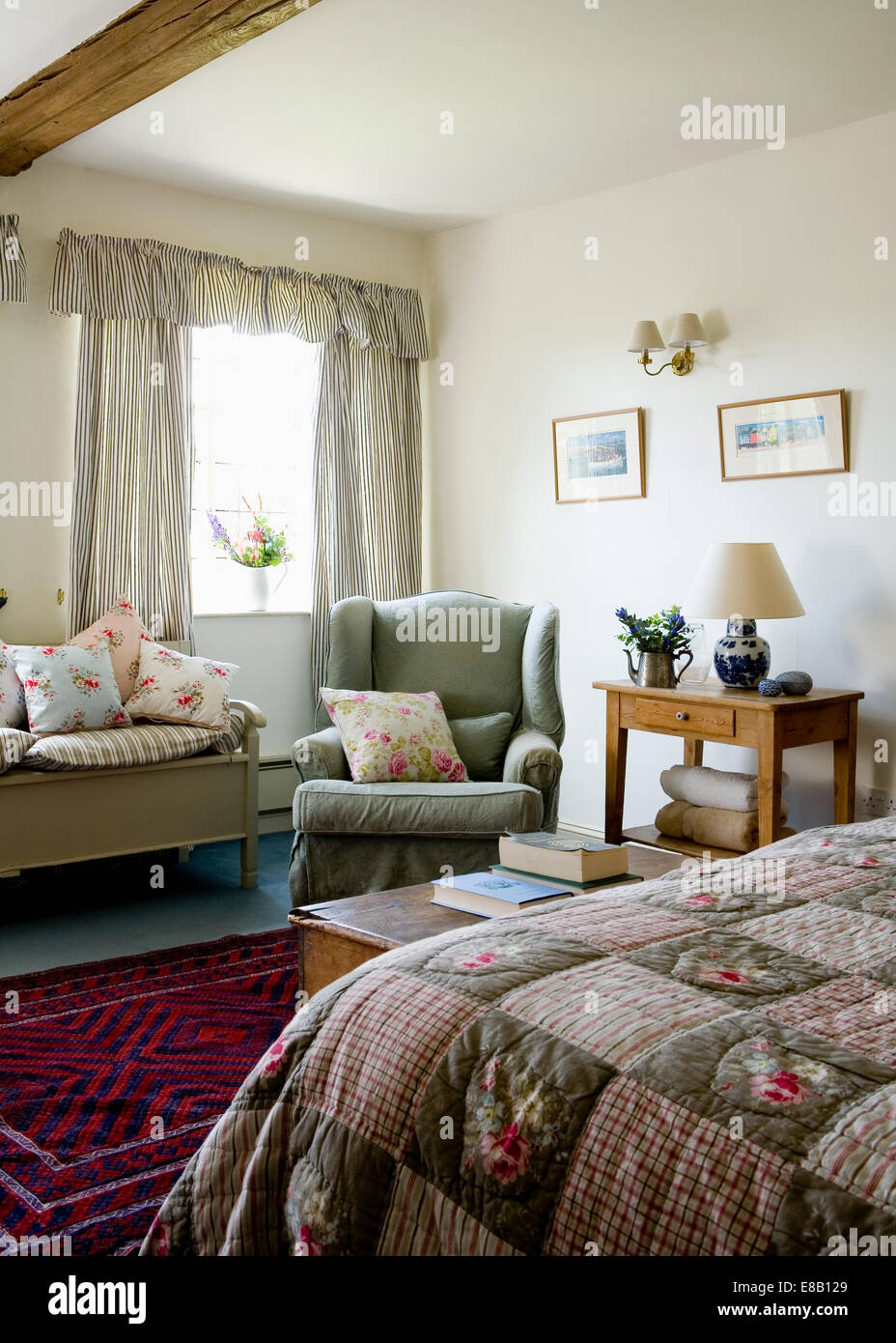 Manta de cama en el país dormitorio con sillón verde Foto de stock
