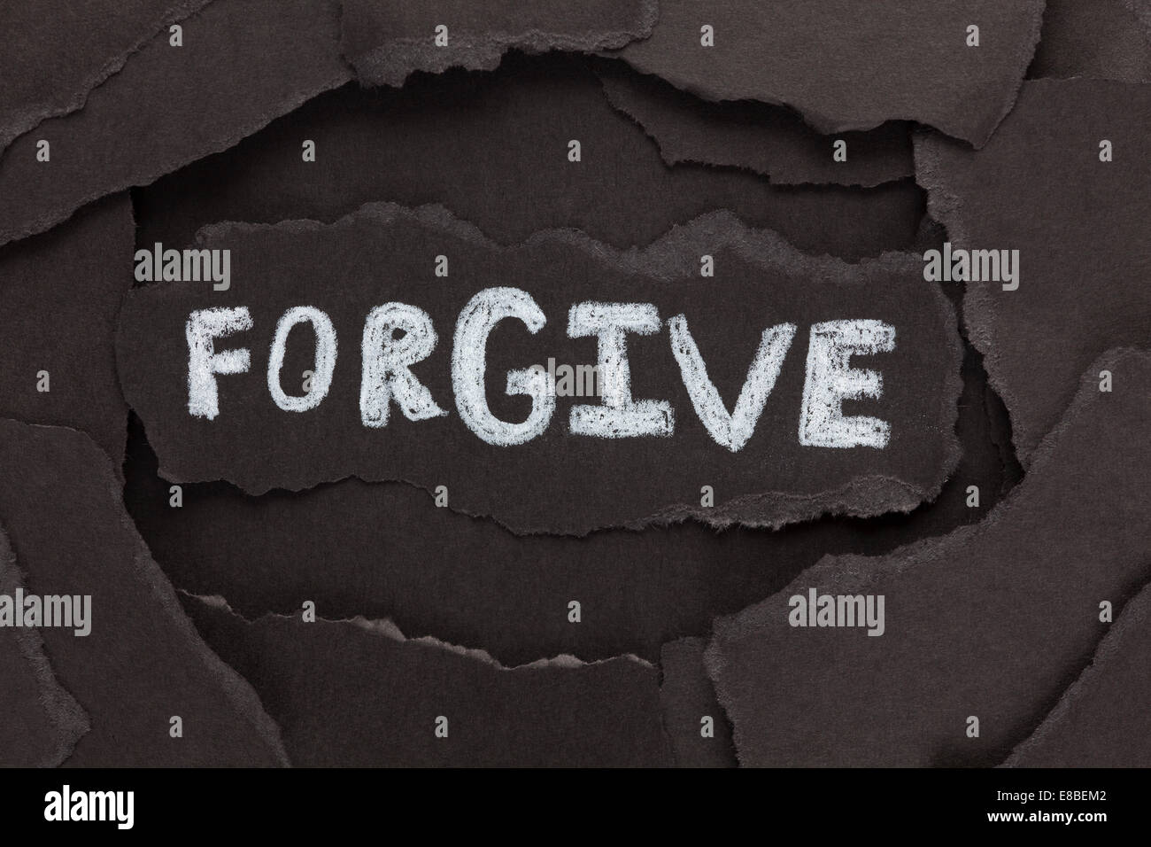 Perdonar. Los pedazos de papel negro y la palabra "perdonar". Close-up. Foto de stock