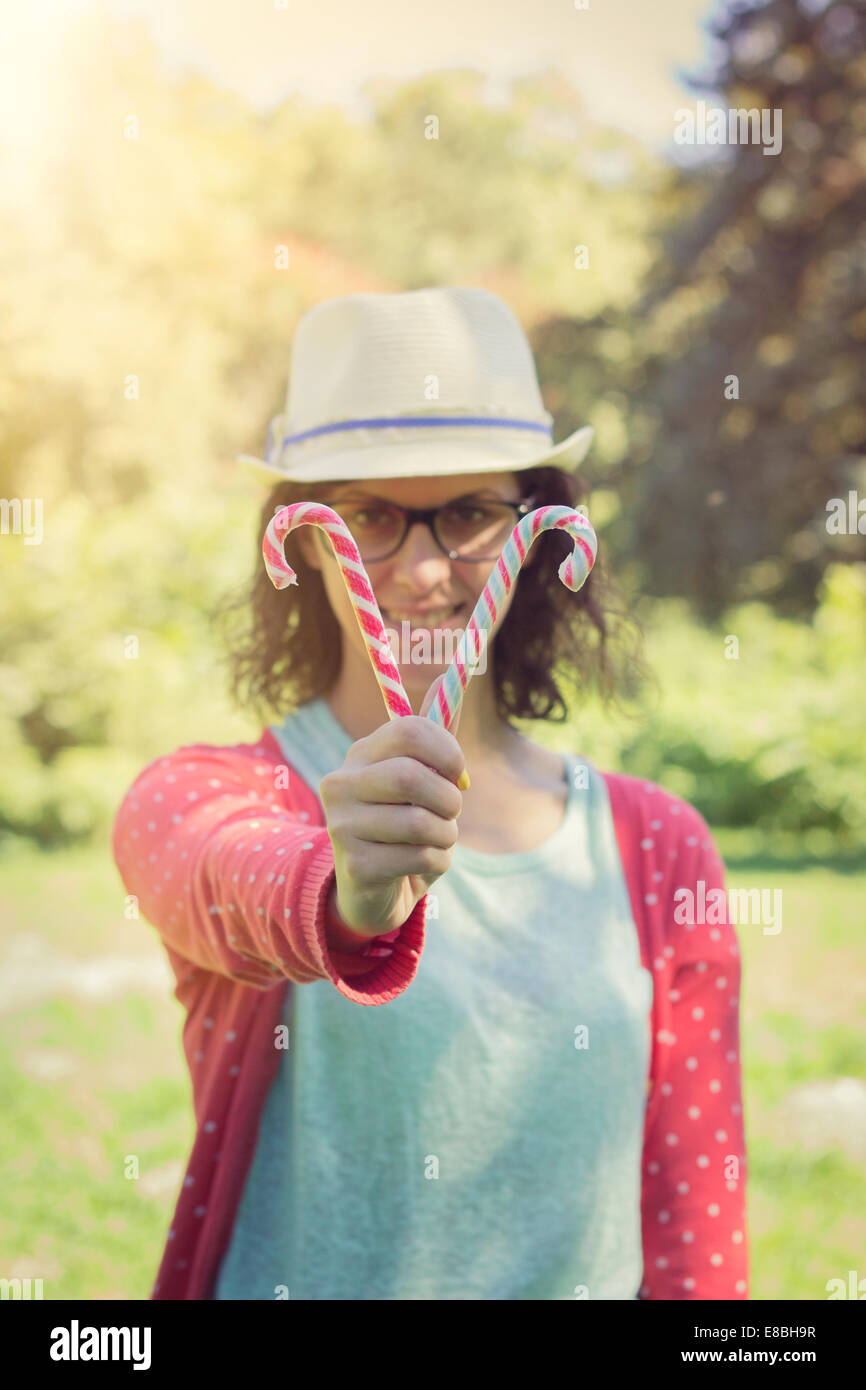 Feliz Hipster adolescente mostrando bastones de caramelo. outdoor shot, colores retro Foto de stock
