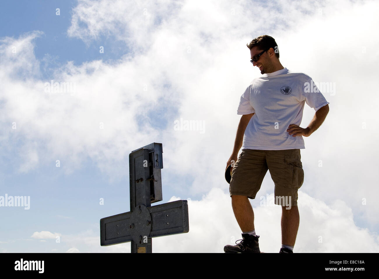 Joven sonriente frente a la cruz. Foto de stock