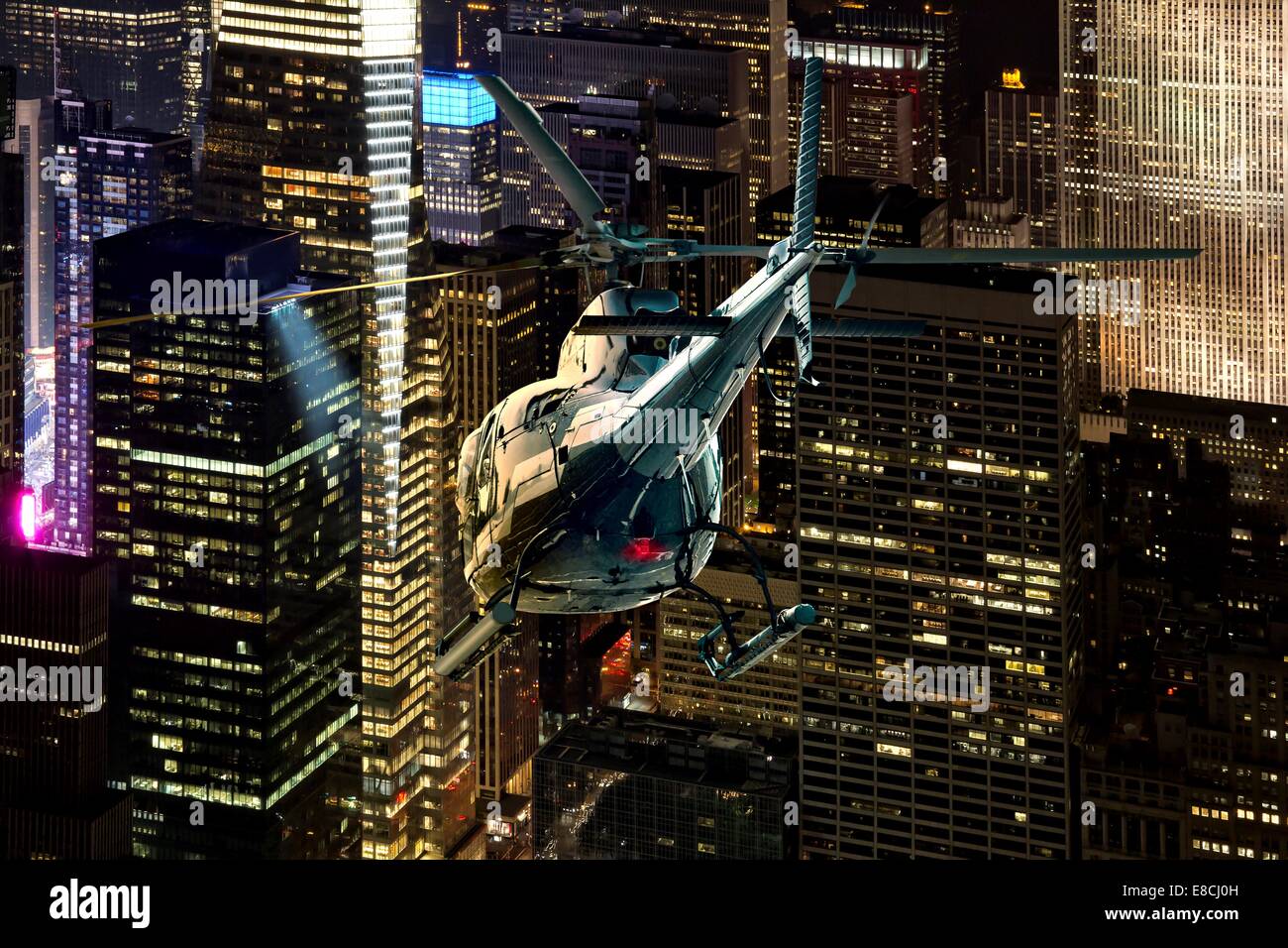 Helicóptero vuelo nocturno entre los rascacielos de Nueva York Manhattan district Foto de stock