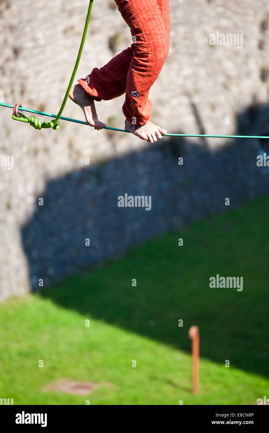 Slacklining es una práctica de equilibrio que utiliza normalmente la cincha poliéster o nylon tensión entre dos puntos de anclaje. Foto de stock