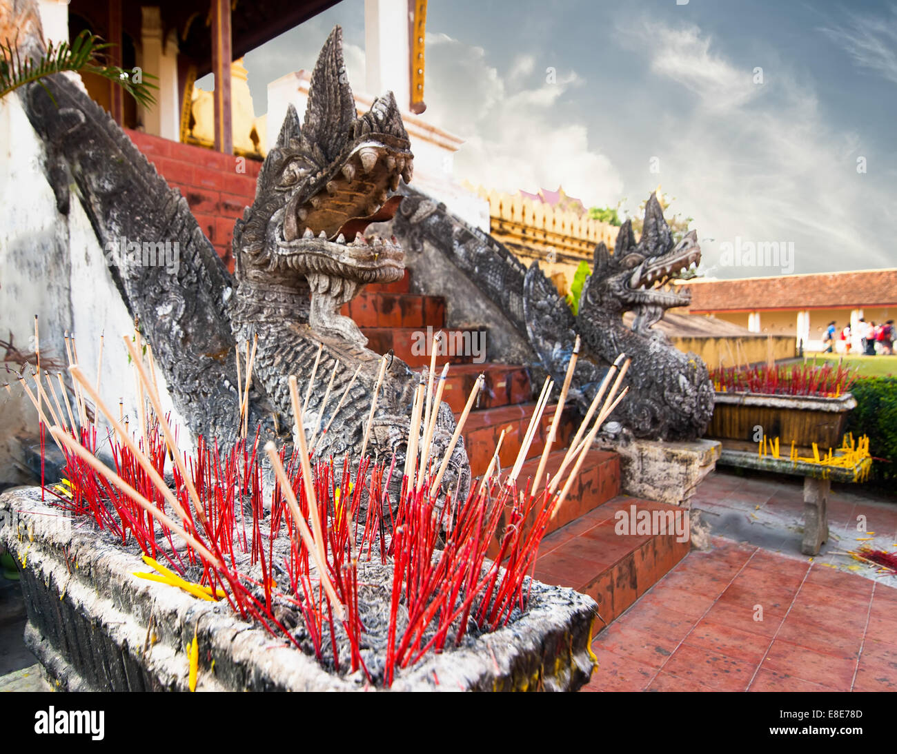 Ritual de aromas de humo palos en Golden pagoda budista Phra That Luang Templo. Vientiane, República Democrática Popular Lao paisaje y destinos de viaje Foto de stock