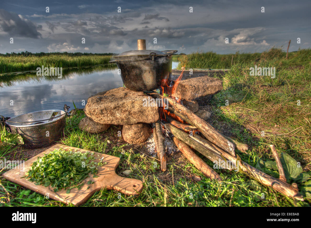 Cooking la comida en un hervidor de agua sobre el fuego de campamento:River Rafting expedición. Polonia Foto de stock