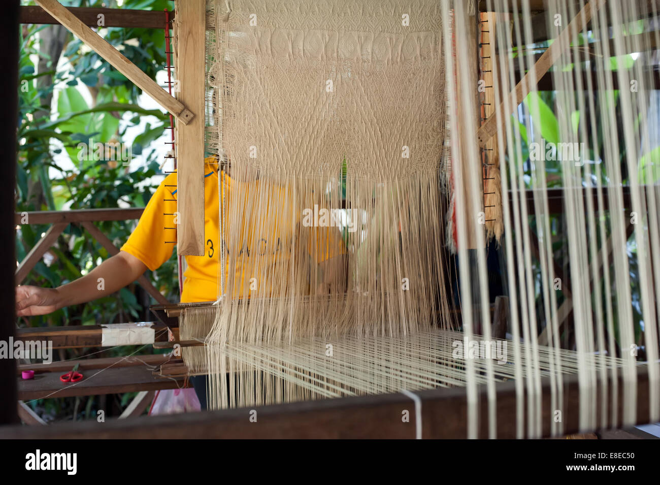Mujer tejiendo seda en forma tradicional en telar manual. Laos Foto de stock