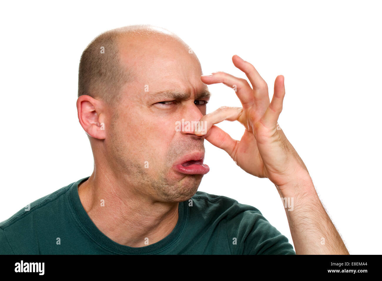 El hombre huele algo stinky y pellizca la nariz para detener el mal olor. Foto de stock
