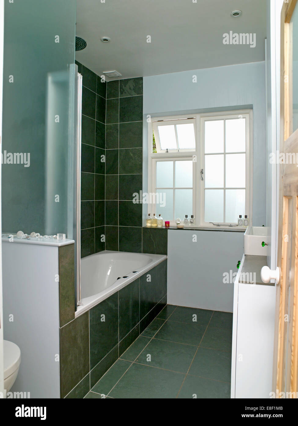 Armario de pared blanco pequeño encima de WC en el pequeño cuarto de baño  moderno con ducha de cristal gabinete Fotografía de stock - Alamy