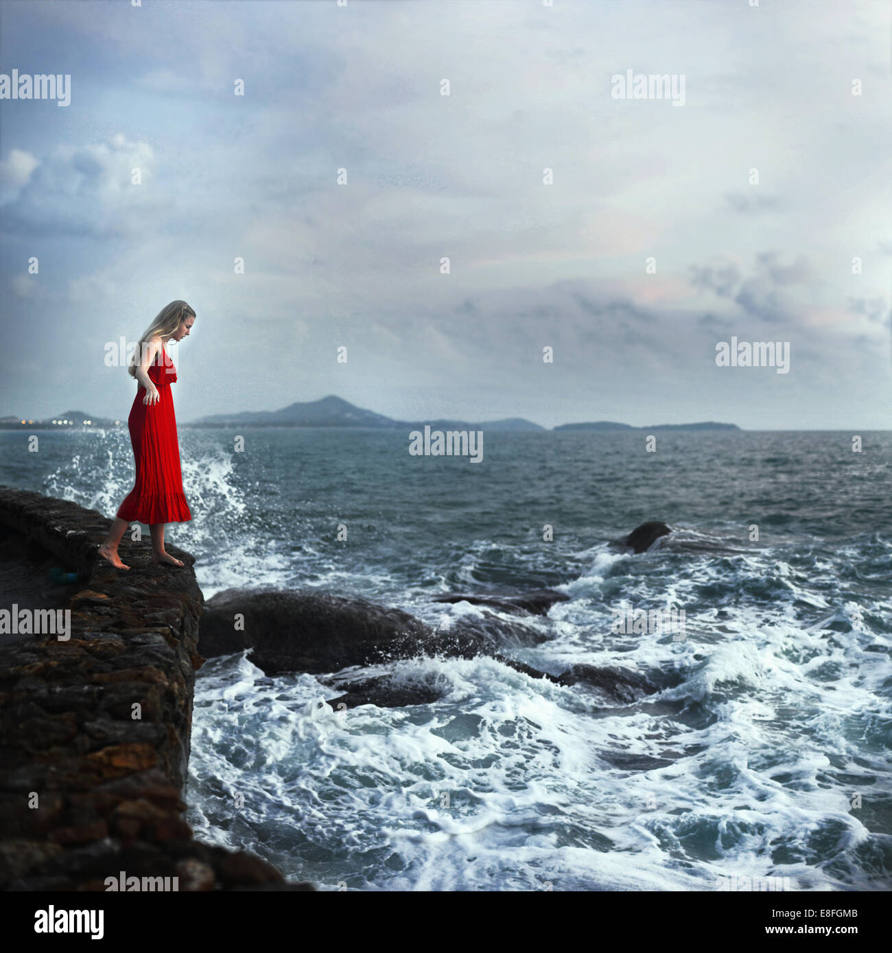 Mujer de pie en una pared mirando hacia el océano, Koh Samui, Tailandia Foto de stock