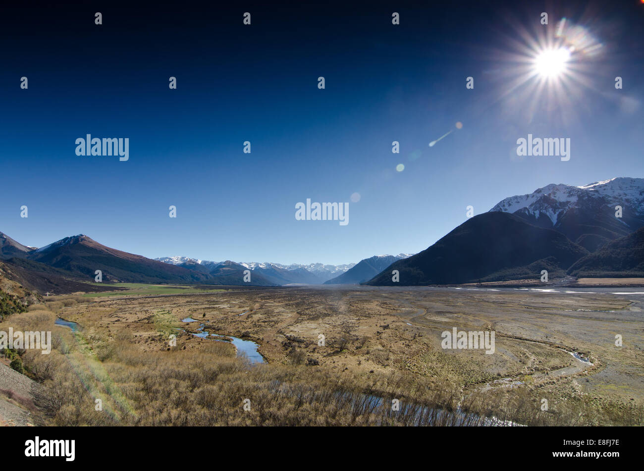 Nueva Zelanda, Canterbury, Arthur's Pass, llanuras bajo la luz solar Foto de stock
