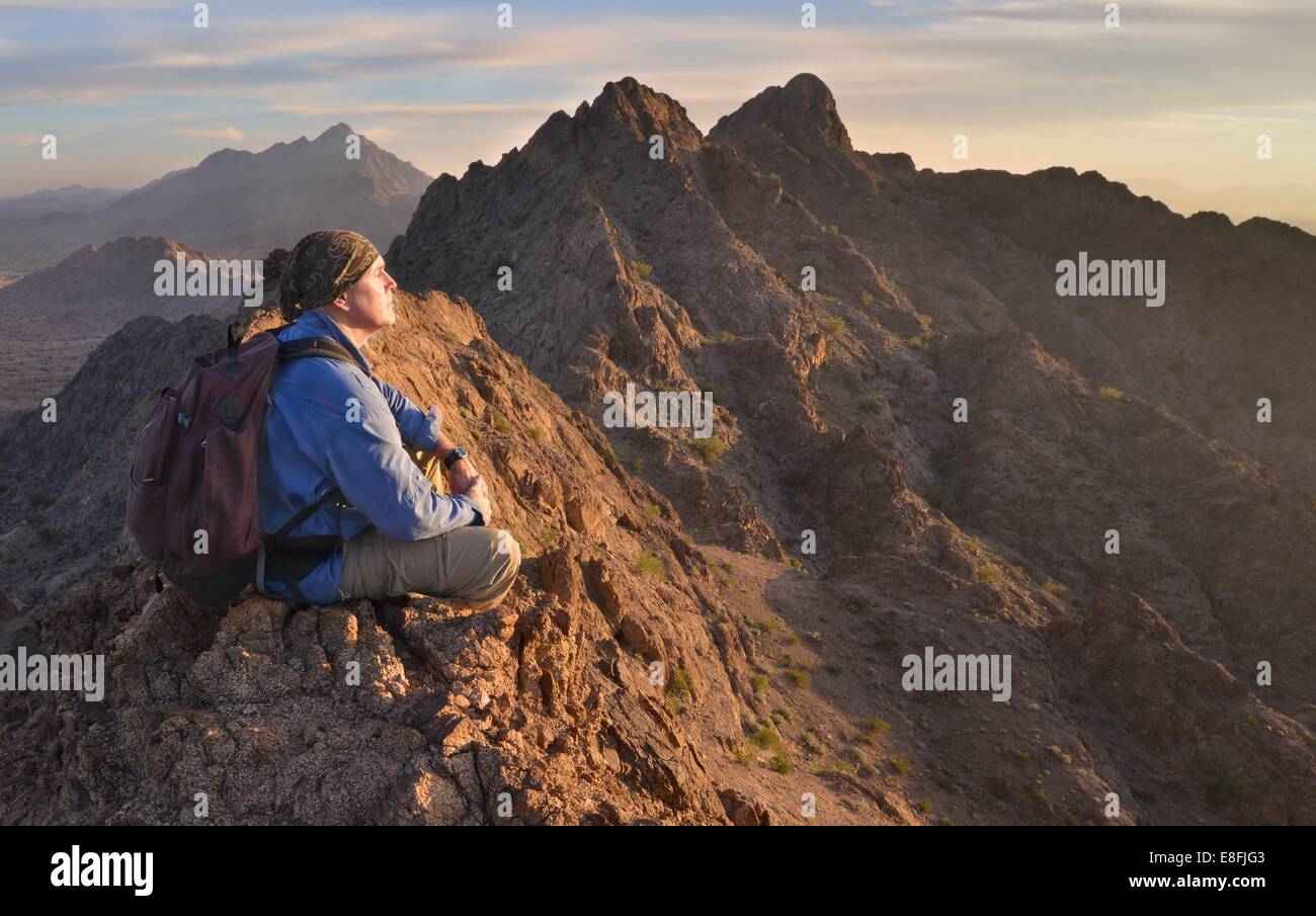 Hombre sentado en la cima de las montañas Mohawk, Arizona, Estados Unidos Foto de stock