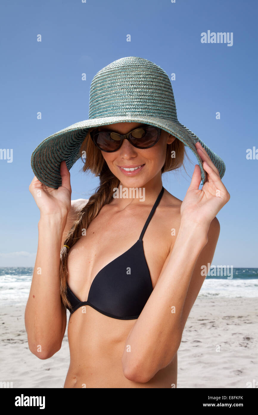 Mujer joven en la playa con sombrero de paja, Ciudad del Cabo, Cabo Occidental, Sudáfrica Foto de stock