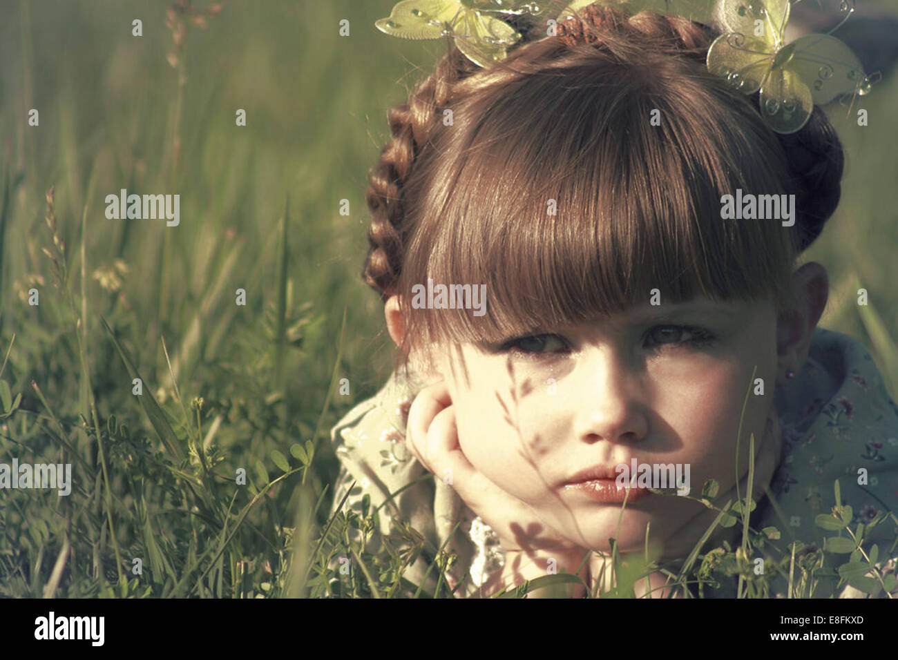 Retrato de una niña tumbada en un prado Foto de stock