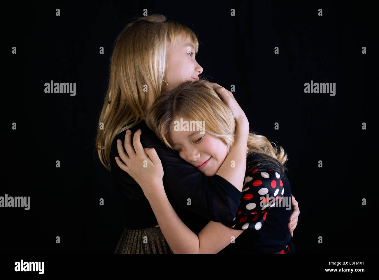 Foto de estudio de dos hermanas (12-13, 16-17) abrazos Foto de stock