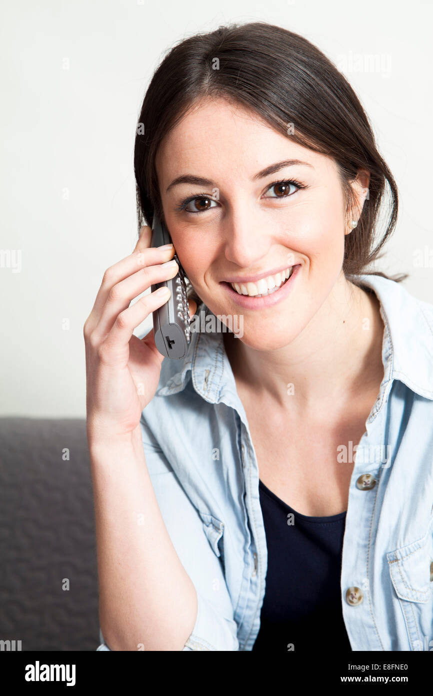 Retrato de una mujer sonriente hablando por teléfono Foto de stock