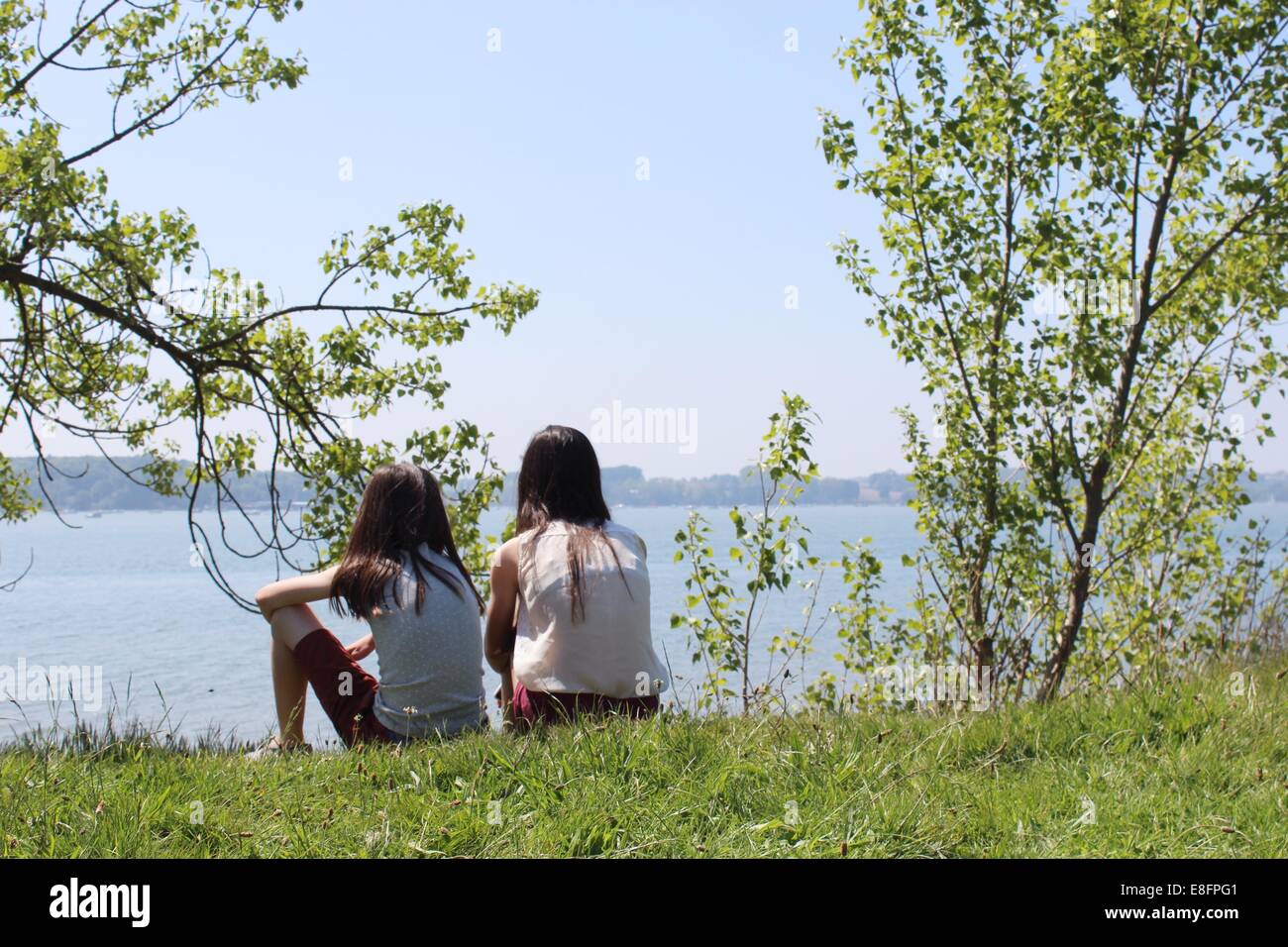 Dos niñas sentadas por río Foto de stock