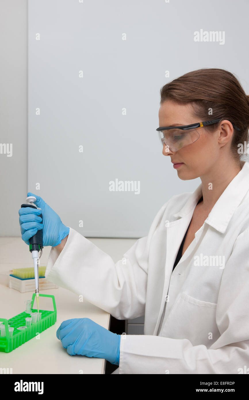 Técnico de laboratorio de muestras en el laboratorio de investigación de pipeteado Foto de stock