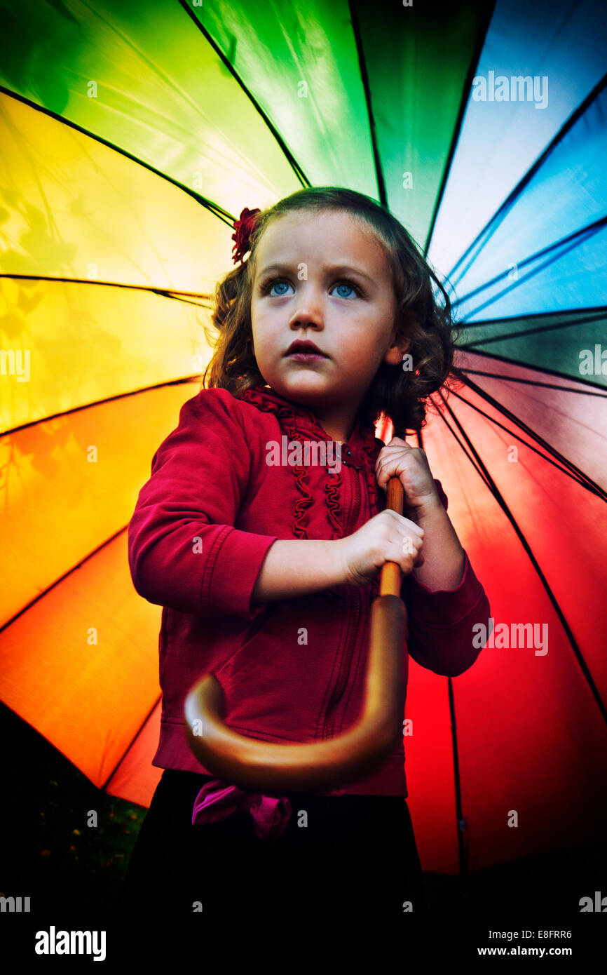 Retrato de una chica sosteniendo un paraguas multicolor del arco iris Foto de stock